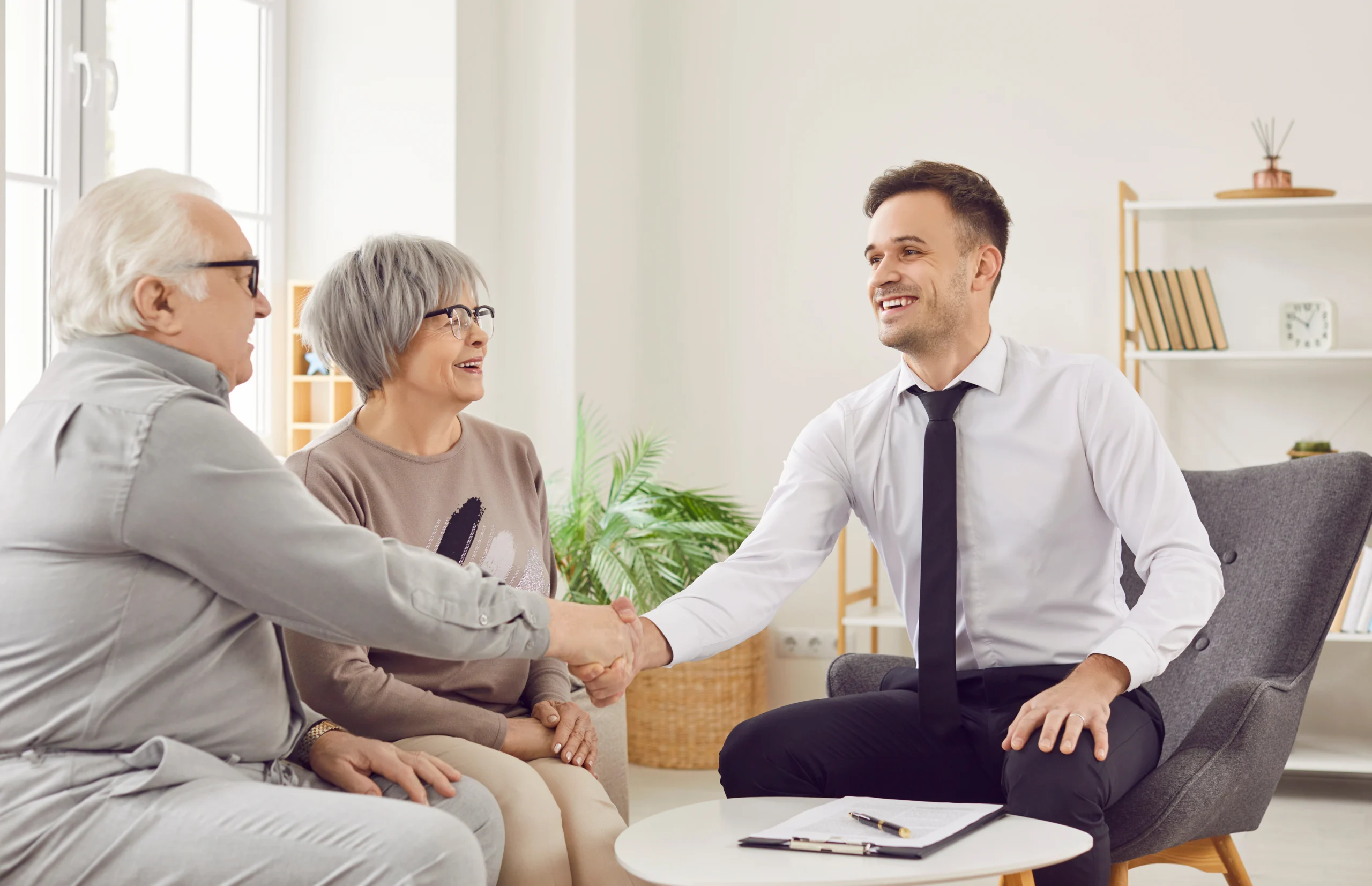 RJHP Agent giving handshake to seated clients RJHP Trusted Partner