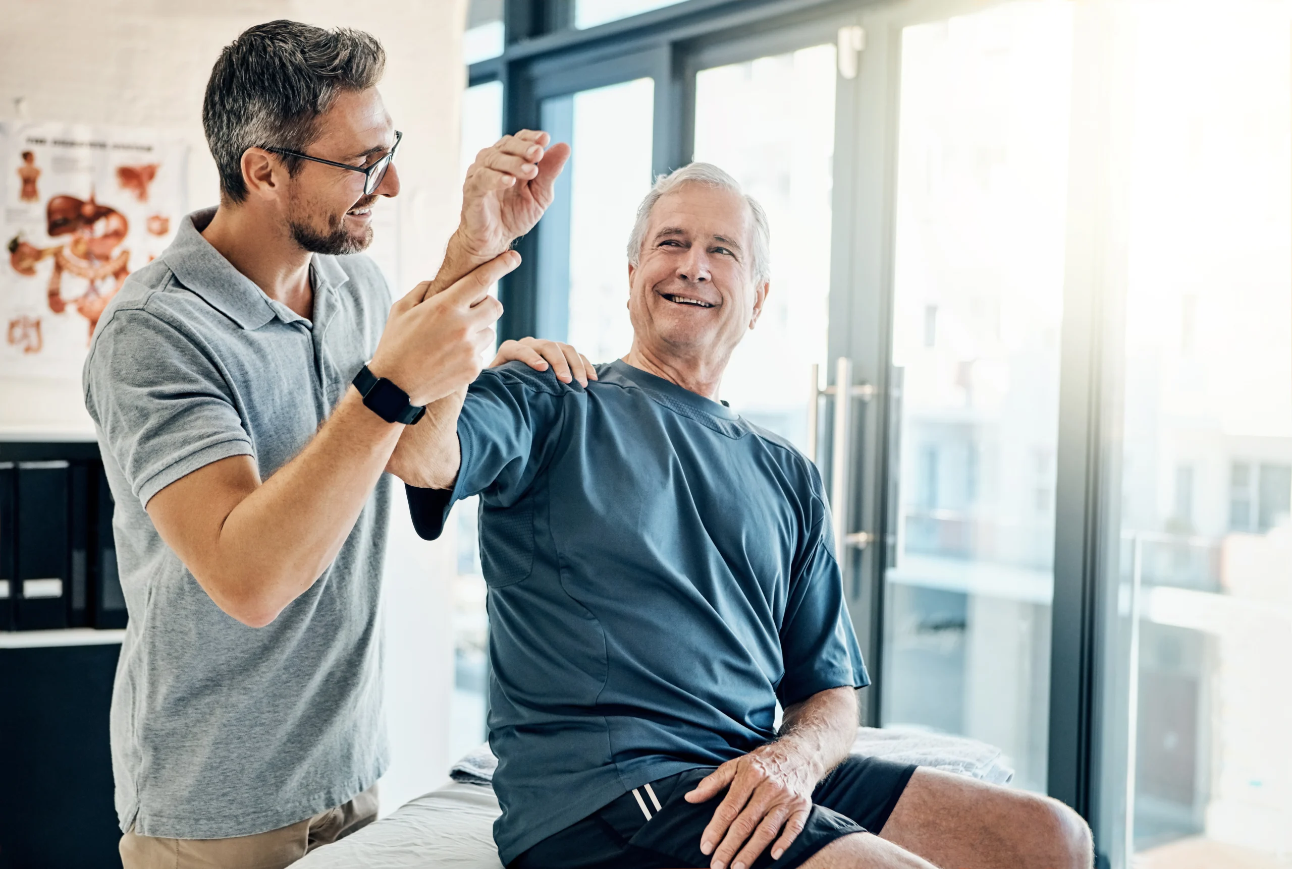 Physical Therapist practicing with older seated gentleman