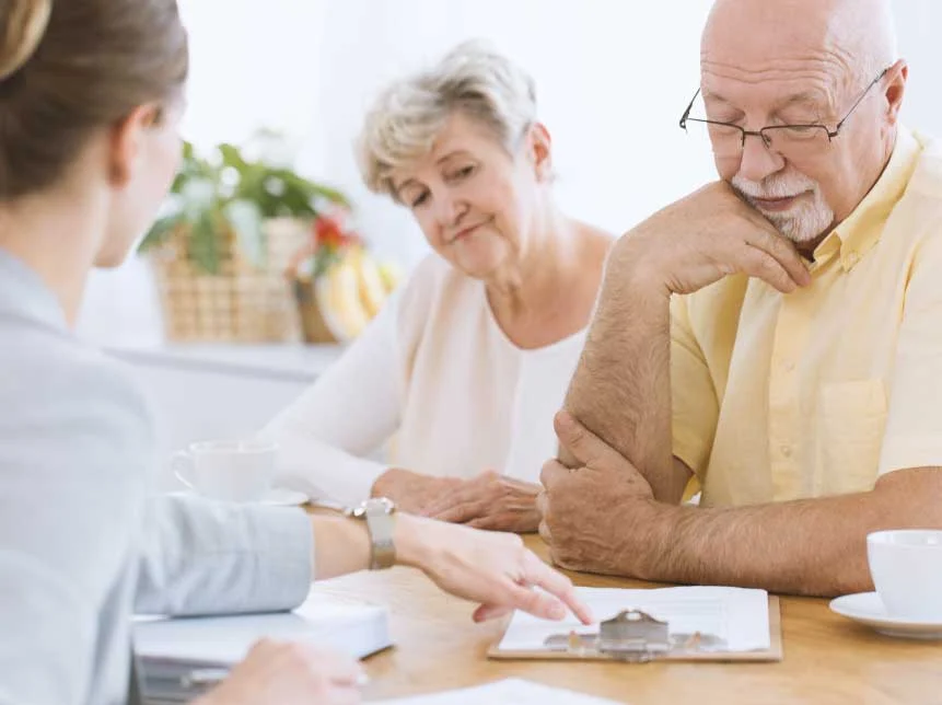 Older couple seated with licensed broker.